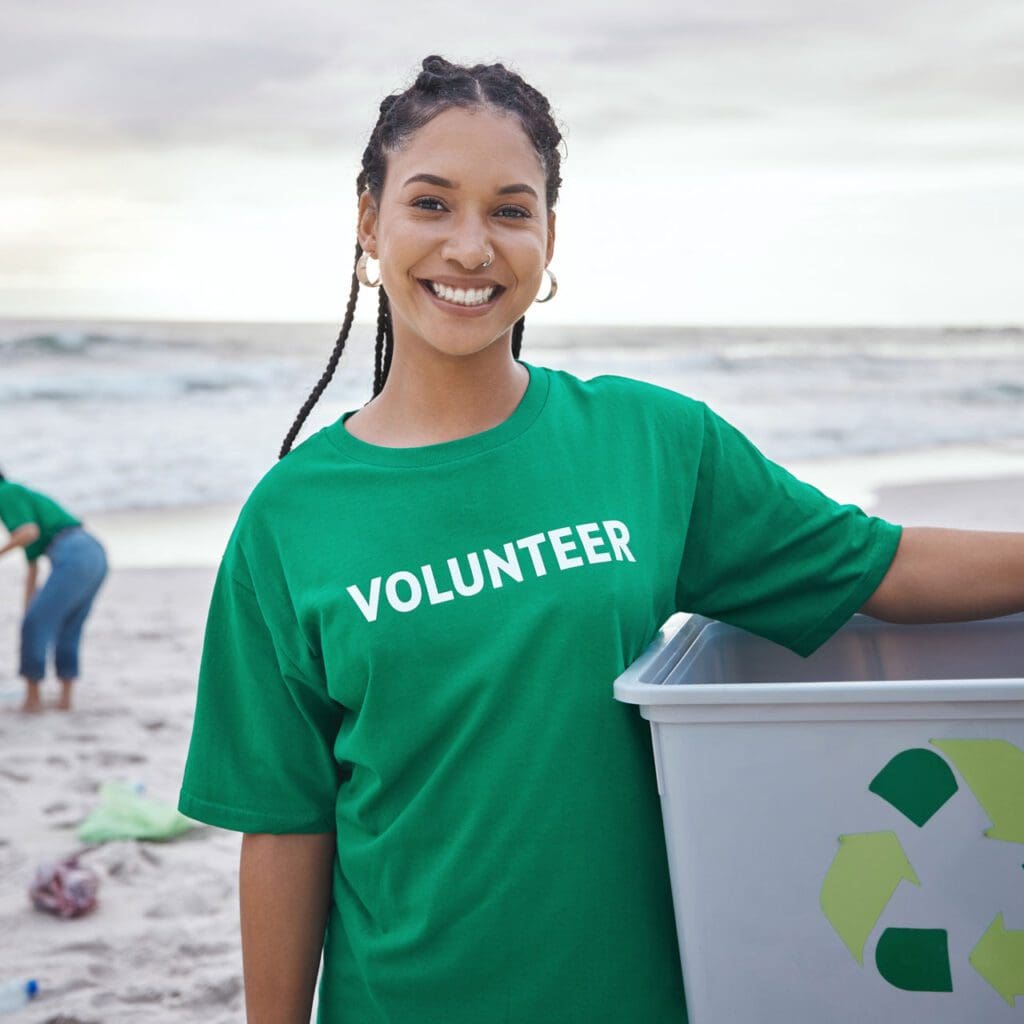 woman at beach wearing a tee shirt that says "volunteer" on it