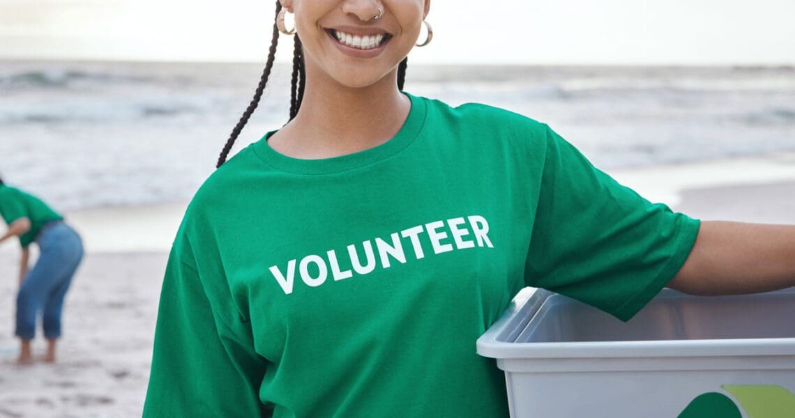 woman at beach wearing a tee shirt that says "volunteer" on it